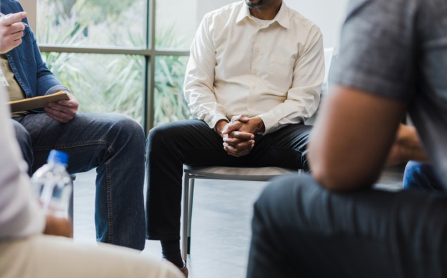 Low angle view men sitting in circle for group therapy