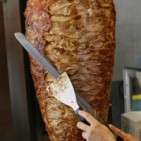 A worker cuts meat from a spit in a Kebab restaurant in Dortmund